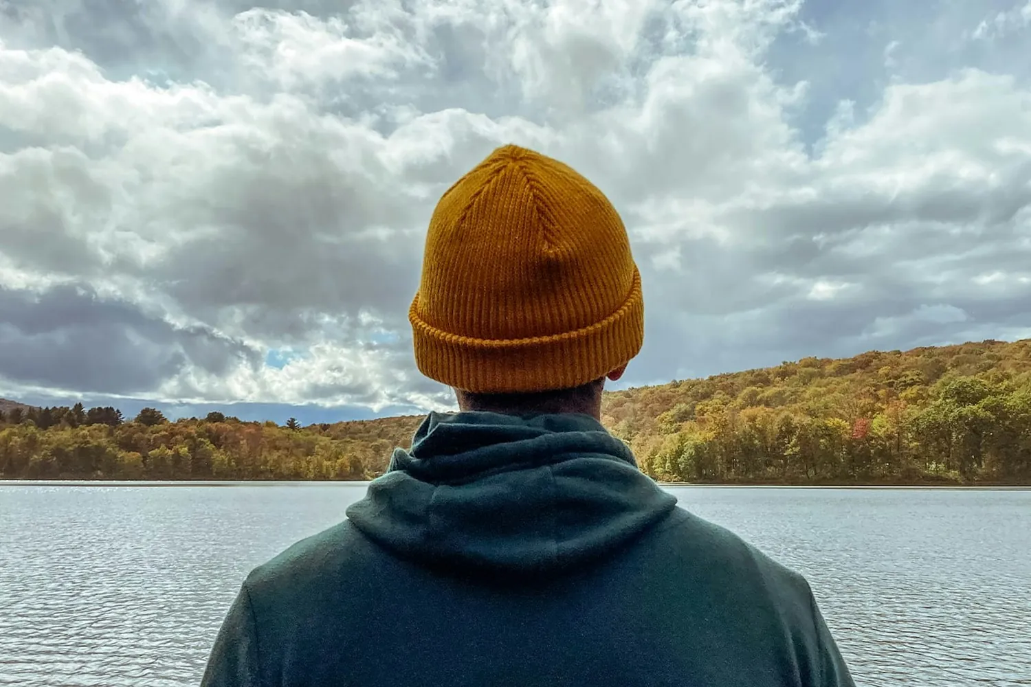 A person outdoors looking across a lake, representing the return to ordinary activity after back treatment