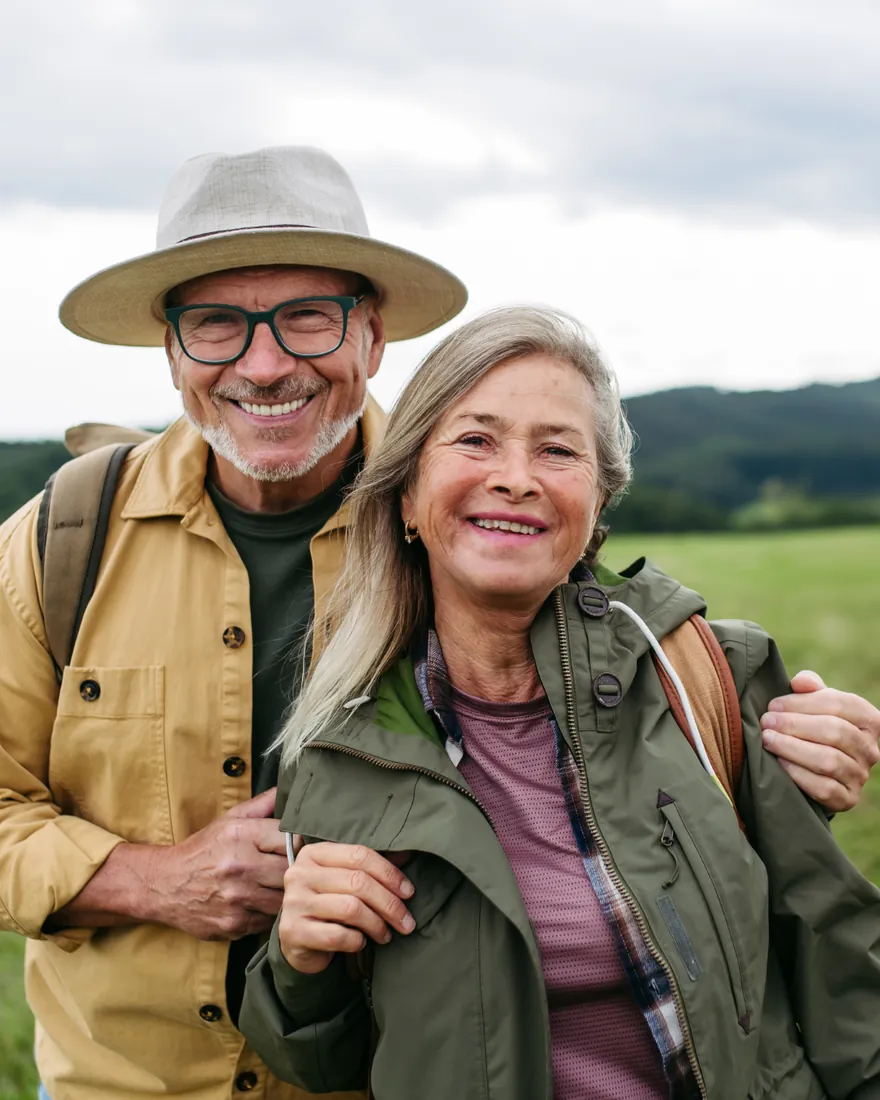 An older couple outdoors on a walk together, smiling